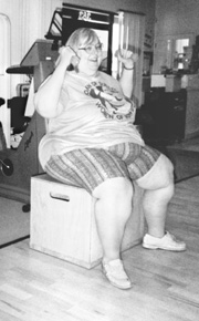 Photo of a woman lifting hand weights while sitting on a chair