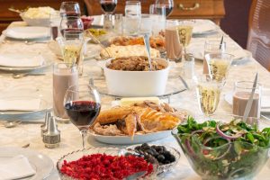 Long Thanksgiving dinner table set for a festive holiday meal with turkey, side dishes, and autumn decor